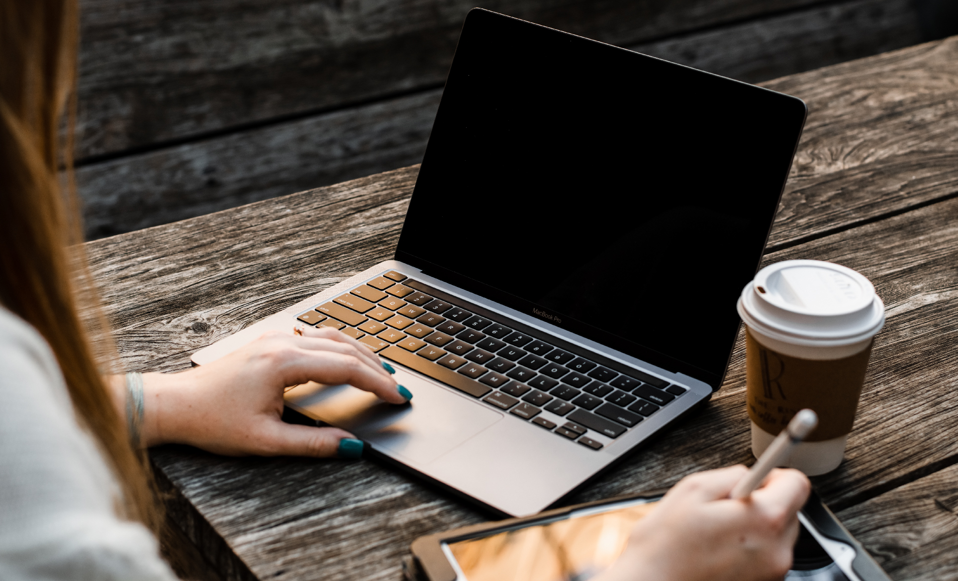 photo of madi balman sitting at a picnic table with her laptop and a coffee